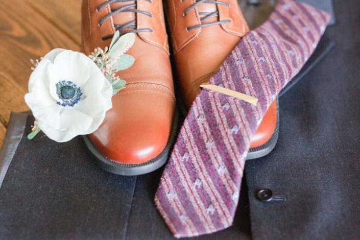 Mike's shoes, tie and boutonniere designed with a single panda anemone, light pink astilbe and greenery.