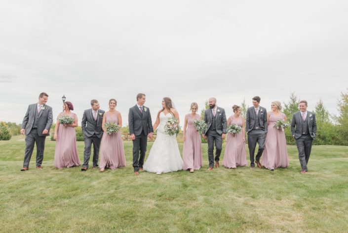 Mauve and Ivory Wedding bridal party; bridesmaids wearing mauve dresses, bride wearing white bridal gown, groom and groomsmen wearing grey suits; mauve and ivory bridal bouquet, greenery bridesmaids bouquets and boutonnieres.