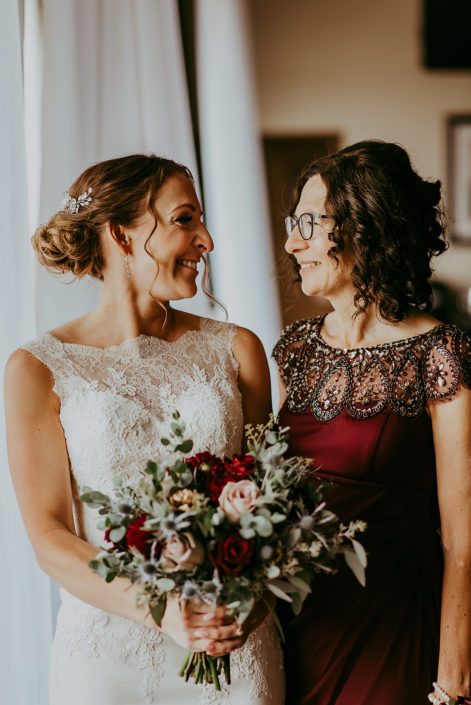 Tanya and Sean's RCMP Wedding - bride and mother with bridal bouquet designed with burgundy dahlias, eryngium, amnesia roses, black baccara roses, rose gold painted succulents and eucalyptus greenery