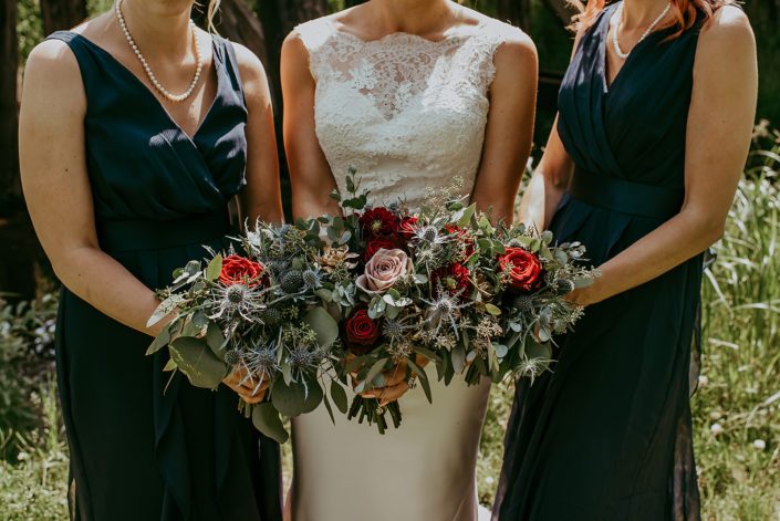 bride and bridesmaid's bouquets made of black baccara roses, amnesia roses, burgundy dahlias, navy eryngium, rose gold succulents and eucalyptus