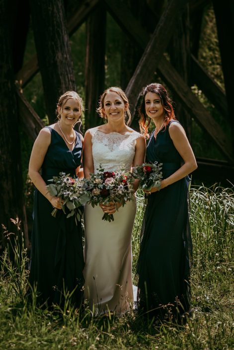 Bride, Tanya, and bridesmaids wearing navy blue with bouquets designed with amnesia roses, black baccara roses, burgundy dahlias, eryngium, rose gold succulents and eucalyptus