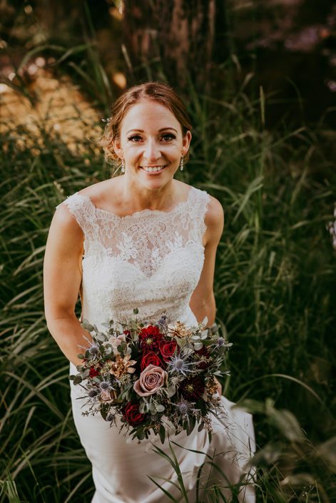 bride Tanya and bridal bouquet designed with amnesia roses, black baccara roses, burgundy dahlias, navy eryngium, rose gold painted succulents and eucalyptus greenery