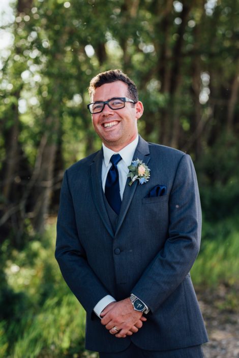 Kyle wearing a blush and blue boutonniere featuring a spray rose, delphinium, babies breath and eucalyptus.
