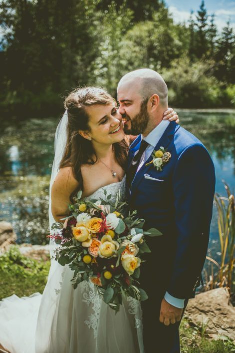 Mustard Yellow Pine and Pond Wedding - Bride and Groom, Bianca and Matt with bridal bouquet featuring golden mustard roses, Juliet garden roses, white ranunculus, Caramel antike garden roses, plum dahlias, craspedia, red astilbe, olive branches and eucalyptus.