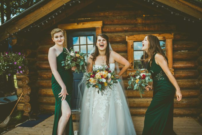 Bride and bridesmaids with mustard yellow bouquets accented by ivory and burgundy.