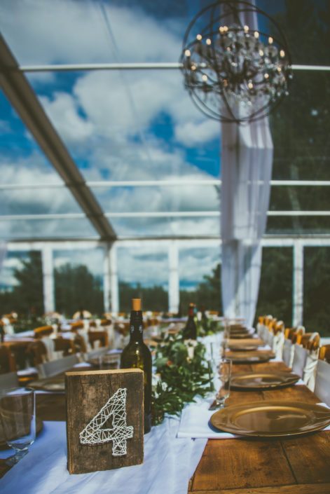 Pine and Pond long tables with gold accents and long greenery garlands.