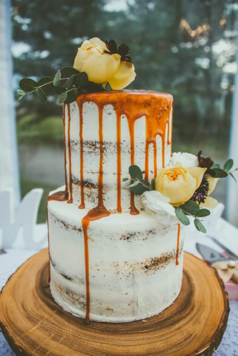Mustard Yellow wedding cake - naked cake with caramel and cake flowers on a wood cookie.
