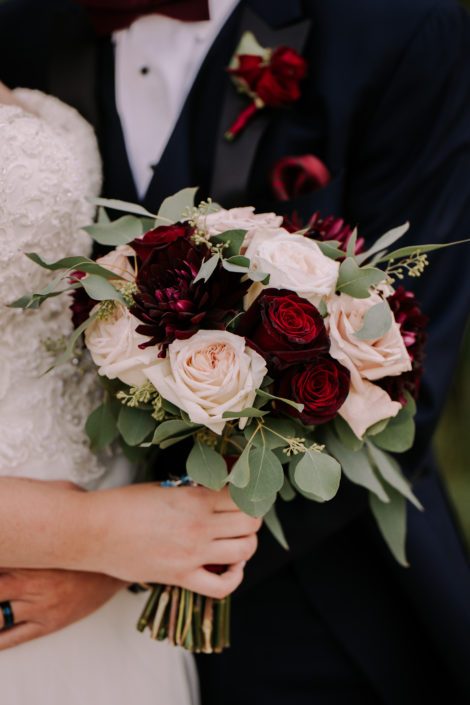 Burgundy and Blush bridal bouquet featuring dalias, quicksand roses, black baccara roses, white o'hara garden roses, and eucalyptus; burgundy rose boutonniere.