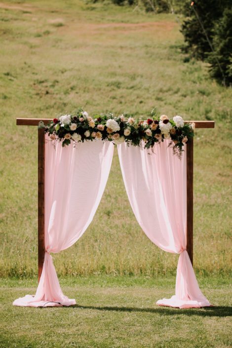 Rustic Chic Burgundy and Blush Archway Arrangement designed with Avignon Chrysanthemum, white o'hara garden roses, white hydrangeas, quicksand roses, salal and eucalyptus.