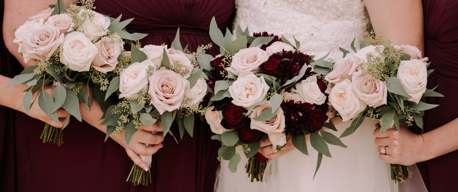Tamara and Kyle's Rustic Chic Burgundy and Blush Wedding bouquets; bridal bouquet featuring burgundy dahlias, white o'hara garden roses, black baccara roses, quicksand roses, and eucalyptus; bridesmaid bouquet designed with blush roses and greenery.