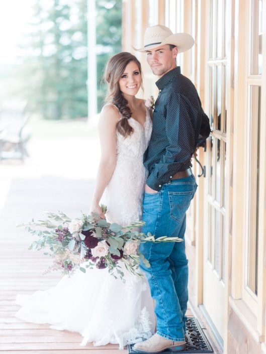 Bride and cowboy groom with oblong country chic bridal bouquet.