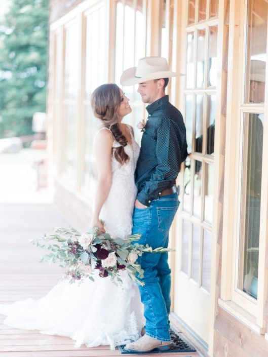 Bride and cowboy groom with burgundy and blush country chic bridal bouquet.