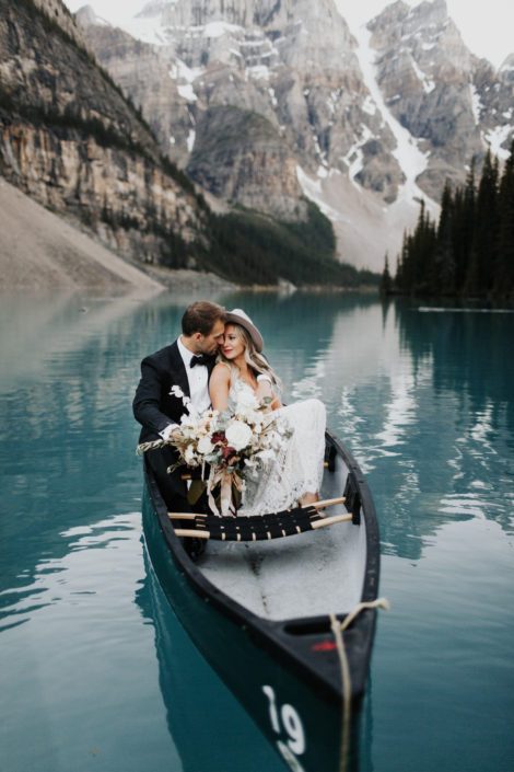 Rocky Mountain Elopement Styled Shoot groom and boho bride in canoe on lake