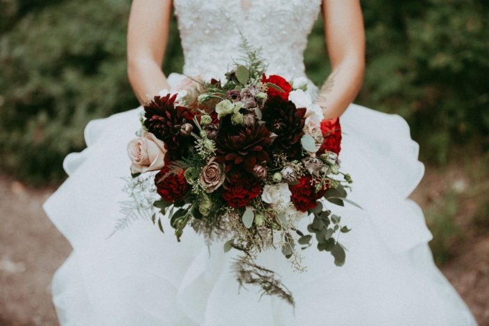 Burgundy, red and mauve bridal bouquet designed with hearts garden roses, amnesia roses, burgundy dahlias, black pearl lisianthus, ivory spray roses, plumosa and eucalyptus