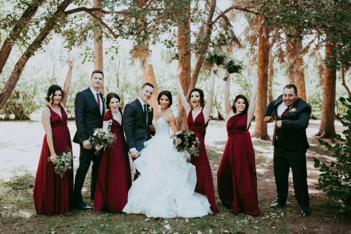 Rikki Lee and Jake's burgundy and dark grey bridal party cheering with boutonnieres and bouquets