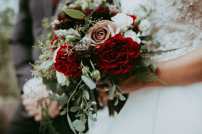 Burgundy and mauve bridal bouquet designed with dahlias, hearts garden roses, black pearl lisianthus, amnesia roses, ivory spray roses, plumosa, seeded eucalyptus and parvifolia eucalyptus