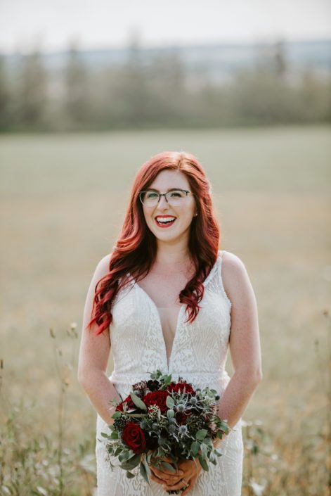 Hailey, holding burgundy bridal bouquet with accents of navy blue