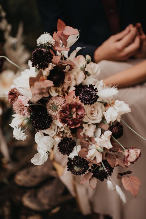 Down the Aisle fall styled shoot bouquet designed with plum, blush, white and orange colored flowers including scabiosa, roses, bunny tails, sweet peas, and fall foliage