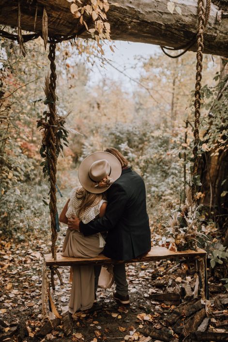 Couple kissing on a swing in the woods
