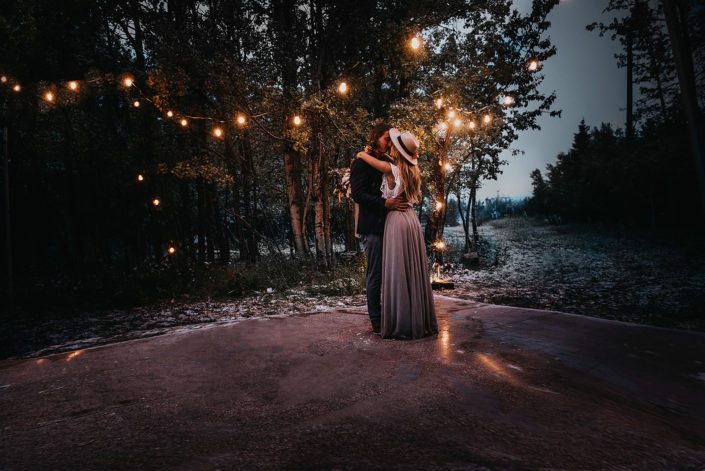 Couple dancing in the woods under twinkly lights