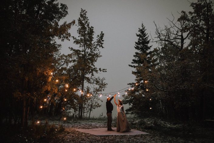 Couple dancing under twinkly lights in the woods