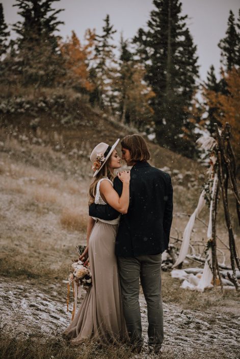 Couple standing next to tee pee for down the aisle fall styled shoot