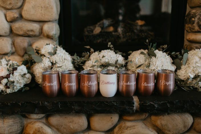 Bridesmaid gift; rose gold wine travel mugs in front of white hydrangea bridesmaid bouquets