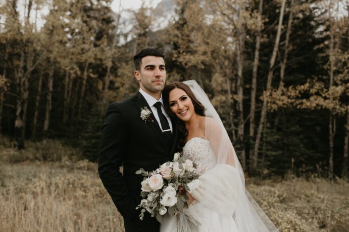 Brittany and Briggs with ivory and blush bridal bouquet featuring burgundy astrantia, white o'hara garden roses, lisianthus, ranunculus, quicksand roses and eucalyptus greenery