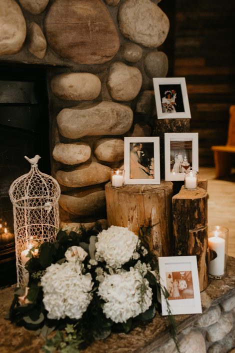 Photo memorial with tree stumps, white bird cage, candles and white hydrangea arrangement