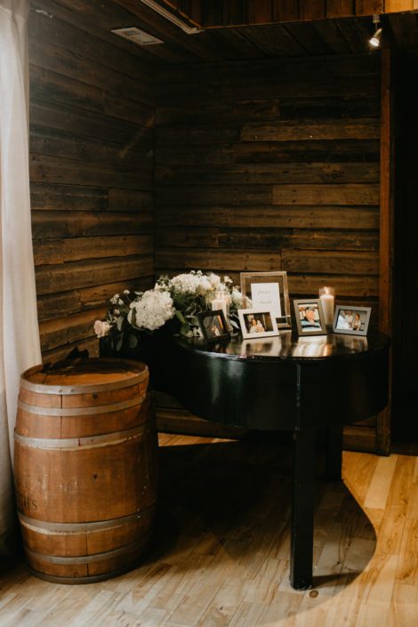 Grand piano covered with photos, candles and white hydrangea flower arrangement
