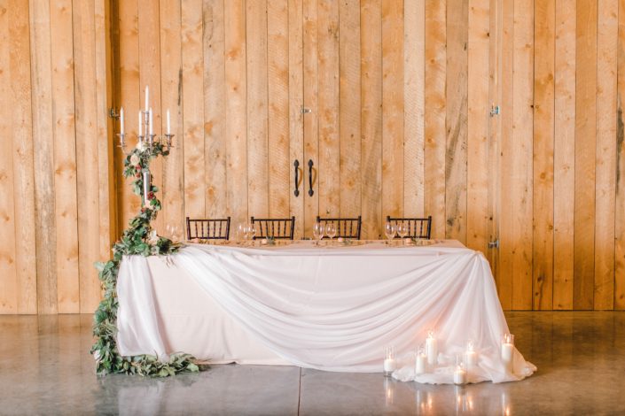 Blush and Burgundy winter wedding photoshoot at Sweet Haven Barn - head table decorated with candlestick and floral garland