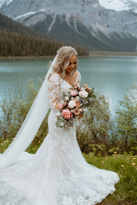 Bride with pink and white bridal bouquet featuring peonies, roses, tulips and eryngium in the Rocky Mountains