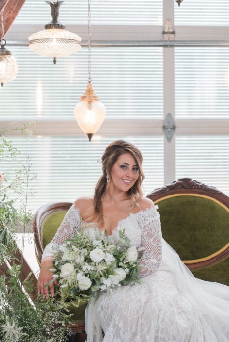 White and green styled shoot bride holding white bridal bouquet