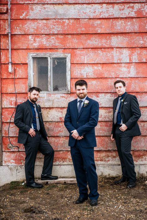 Nick and groomsmen wearing boutonnieres made with mauve, ivory and blye flowers