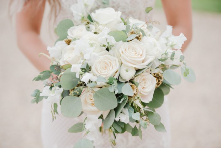 Natural White and green wedding bridal bouquet designed with white astilbe, ranunculus, Tibet roses, sweet peas, gold scabiosa pods and eucalyptus