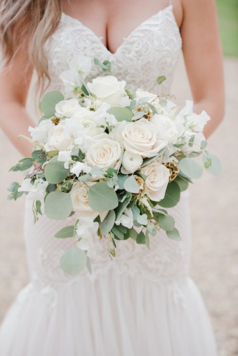 Natural white and green bridal bouquet designed with Tibet roses, white ranunculus, sweet peas, astilbe, gold scabiosa pods, gunni, silver dollar and seeded eucalyptus