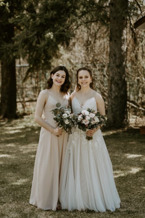Bride and bridesmaid with blush, white and burgundy bouquets