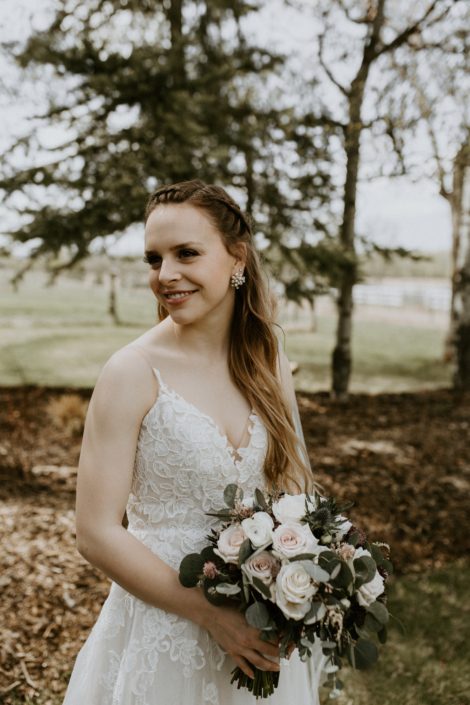 Rustic Elegance bride, Emily, wearing white lace bridal gown with vintage and rustic vibes, holding a blush, white and burgundy bridal bouquet