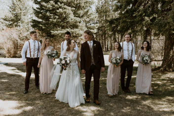 Emily and Jacob's Bridal party walking with blush, white and burgundy bouquets
