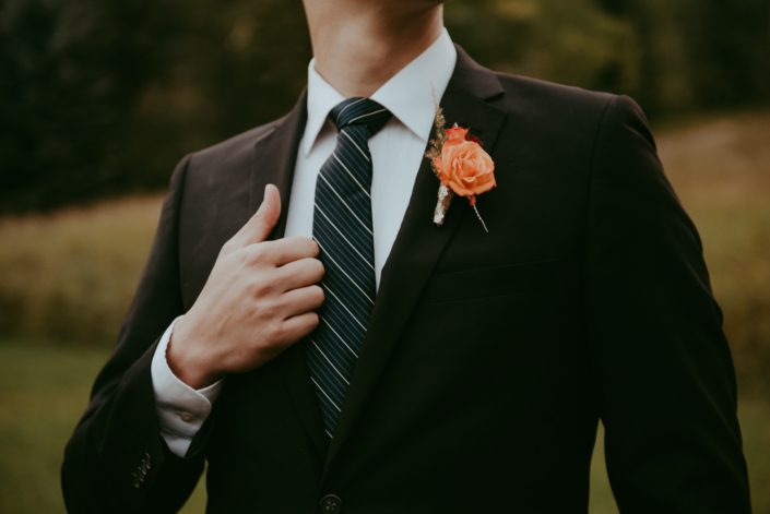 Bold orange boutonniere designed with a rose