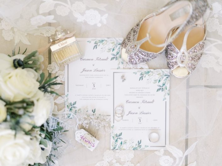 Elegantly Whimsical White and Silver Bridal Flat Lay of shoes, stationary, flowers, veil