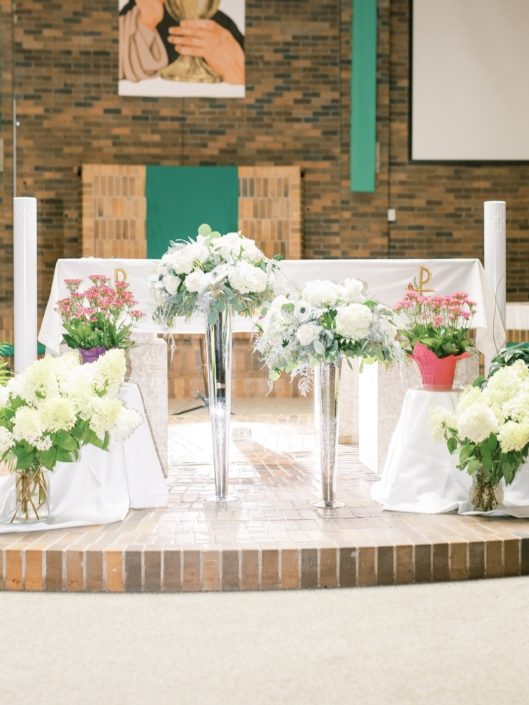 Ceremony alter arrangements designed atop tall silver mercury glass vases with white flowers