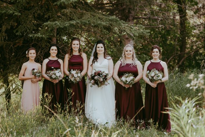 Burgundy and dusty rose bride and bridesmaids; bridesmaids wearing burgundy dresses with blush bouquets; bride with burgundy and dusty rose bridal bouquet; flower girl wearing dusty rose with burgundy and dusty rose bouquet