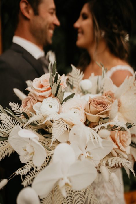 blush and white rustic bridal bouquet designed with roses, ranunculus, orchids, bunny tail, astilbe, bleached bracken fern and olive branches
