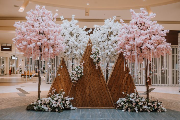 Wooden mountains backdrop decorated with artificial botanicals and Easter Eggs for the Bower Place Easter 2021 Display.