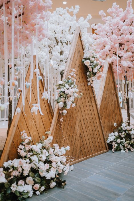 Wooden mountains decorated with white, peach and pink artificial flowers