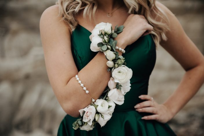 Upclose of Sydney's white statement corsage, pearl wristlet, ranunculus, roses, eucalyptus