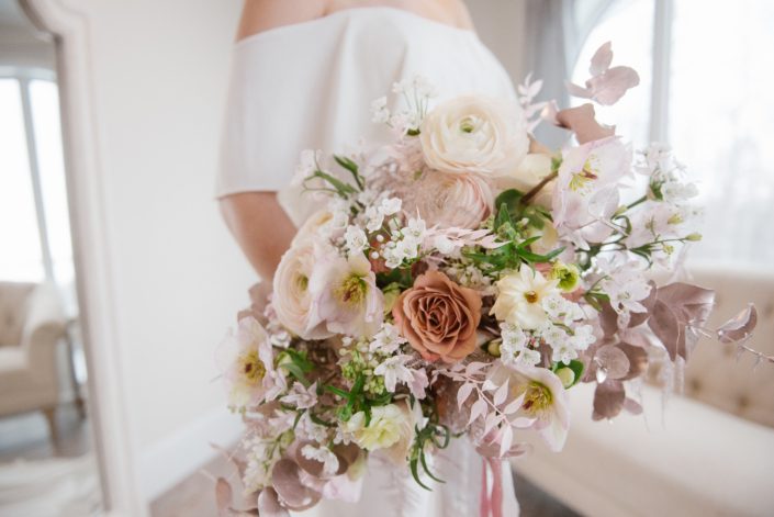 pink, white and rose gold flowers; roses, ranunculus, hellebores, cosmos, alyssum, pink bleached Italian ruscus, rose gold painted plumosa, rose gold painted eucalyptus