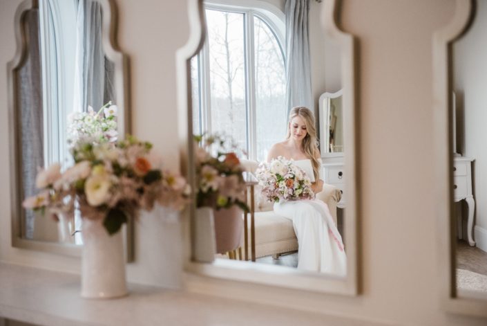 Bride in mirror holding pink and white bridal bouquet at Hilltop Wedding Centre