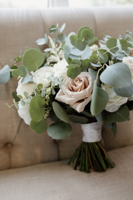 Rusty Rose Wedding Bridal Bouquet designed with white astilbe, white astrantia, white ranunculus, playa blanca roses, quicksand roses, white majolica spray roses and a mixed variety of eucalyptus greenery